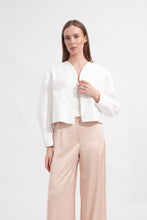 Load image into Gallery viewer, Woman wearing a white blouse and beige pants on a light gray background