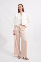Load image into Gallery viewer, Woman wearing a white blouse and beige pants on a white background