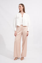 Load image into Gallery viewer, Woman wearing a white top and beige pants on a white background