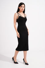 Load image into Gallery viewer, Woman wearing a black sleeveless dress with a slit on a white background