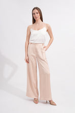 Load image into Gallery viewer, Woman wearing a white top and beige pants on a white background
