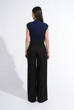 Load image into Gallery viewer, A woman shown from the back wearing a navy blue sleeveless top and black wide-leg trousers, standing against a plain white studio background.
