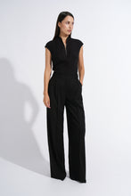 Load image into Gallery viewer, A woman modeling a black sleeveless top and matching black wide-leg trousers against a plain white studio background.
