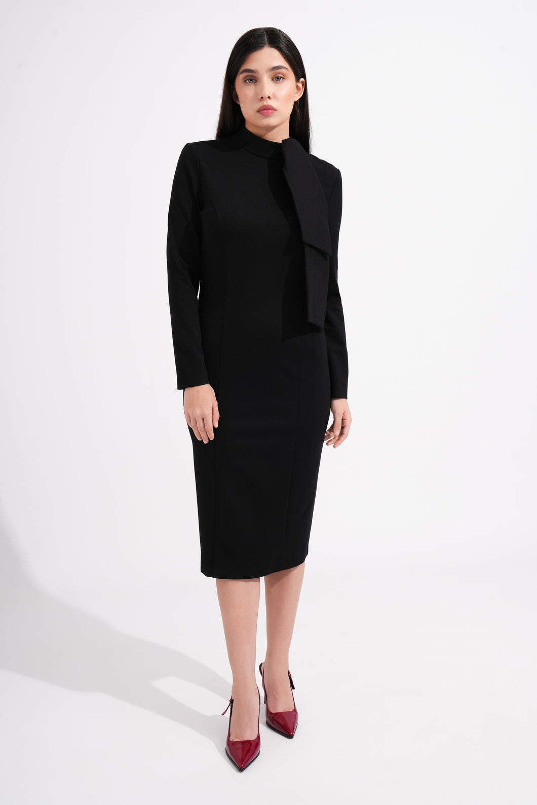 Woman wearing a black outfit with a high neck bow