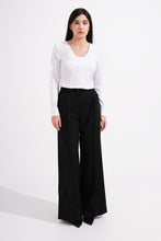 Load image into Gallery viewer, Woman wearing a white blouse and black wide-leg pants on a white background
