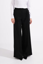Load image into Gallery viewer, Person wearing black wide-leg pants and a white top on a white background
