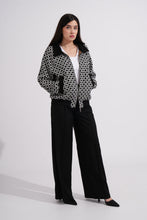Load image into Gallery viewer, Woman wearing a black and white patterned jacket with black pants on a white background
