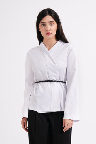 Woman wearing a white blouse and black pants on a white background